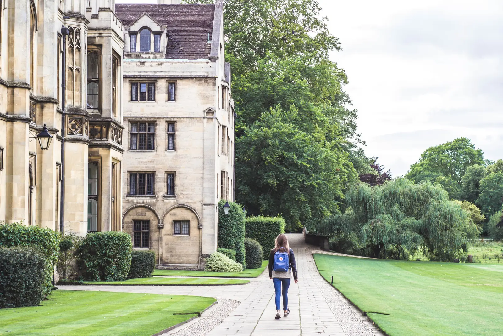 A student walking along a path on a college campus